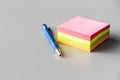 Blank sticky paper notepad and pen on gray table Royalty Free Stock Photo