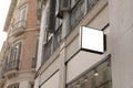 Blank store sign in a classic urban setting, perfect for businesses to superimpose their logo or message in a realistic