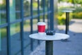 Blank take away kraft coffee cup on outdoor cafe table ,