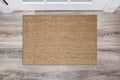 Blank tan colored coir doormat before the white door in the hall. Mat on wooden floor, product Mockup Royalty Free Stock Photo