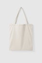 Blank Tote Canvas Bag Mockup hanging on a wall.