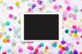 Blank touchscreen display with colorful confetti on white background. Flat lay of touchpad computer on white background