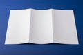 Blank tri fold brochure on blue background to replace your design or message.