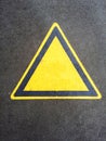 Blank triangle hazard, attention, warning, danger sign on the black asphalt