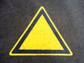 Blank triangle hazard, attention, warning, danger sign on the black asphalt