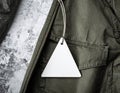 Blank Triangle Tag Attached to Olive Green Jacket with Textured Background Royalty Free Stock Photo
