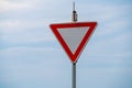 Blank triangle warning road sign against the blue sky