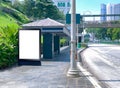 Blank vertical advertising poster banner mockup at bus stop shelter by main road, at city centre; out-of-home OOH billboard media Royalty Free Stock Photo