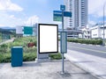 Blank vertical advertising poster banner mockup at empty bus stop shelter by main road, greenery behind; out-of-home OOH vertical Royalty Free Stock Photo