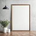 Blank vertical poster frame leaning on a white wall in a modern interior with a plant and pendant light Royalty Free Stock Photo