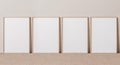 Blank vertical poster frame mock up standing on beige floor. Four wooden frames isolated in Scandinavian interior Royalty Free Stock Photo