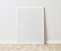 Blank Vertical white frame on wooden floor with white wall, 3:4 ratio, 30x40 cm, 18x24 inches, poster frame mock up, 3d rendering. Royalty Free Stock Photo
