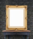 Blank vintage golden photo frame lean at black brick wall on woo Royalty Free Stock Photo