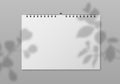 Blank wall calendar. Empty planner front view with white paper pages and plant shadow. Date event, month diary, calendar