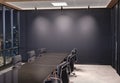 Blank wall Mockup in dark modern office with windows and spotlights. Empty company meeting room 3D rendering Royalty Free Stock Photo