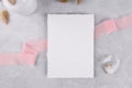 Blank wedding invitation stationery card mockup on grey stone table background with pink ribbon, 5x7