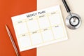 The Blank weekly plan notice block and medical stethoscope on beautiful background