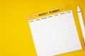 The Blank weekly plan notice block on yellow background. Empty schedule and a pen Royalty Free Stock Photo