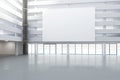 Blank white billboard in the hall of empty building with concrete floor, mock up