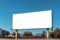 Blank white billboard or large advertising display against blue sky - front view. Mockup, advertising, isolated white screen, Royalty Free Stock Photo