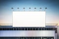 Blank white billboard with spotlights on top of industrial building on evening sky background. 3D rendering Royalty Free Stock Photo