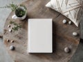 Blank white book cover mockup with a coffee cup vase and home decor on a table Template. Royalty Free Stock Photo