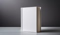 A blank white book standing upright on a plain grey background, a concept of branding mockup. Generative AI Royalty Free Stock Photo