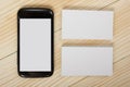 Blank white business cards and smartphone on wood background Royalty Free Stock Photo