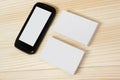 Blank white business cards and smartphone on wood background Royalty Free Stock Photo