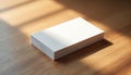 Blank white business cards stack on wood table. Sunlight creates shadow patterns. Perfect for branding mockups, graphic design, Royalty Free Stock Photo