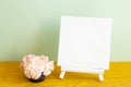 Blank white canvas with carnation flowers on wooden table Royalty Free Stock Photo