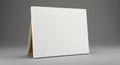 A blank white canvas mounted on a wooden easel is shown against a plain gray Royalty Free Stock Photo