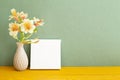 Blank white canvas and vase of Yellow Alstroemeria flowers on wooden table Royalty Free Stock Photo