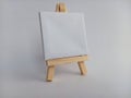 Blank white canvas on a wood easel on a white background