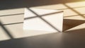 Blank white card casting a grid shadow from window blinds on a textured surface Royalty Free Stock Photo