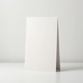 A blank white card stands upright on a smooth, white surface. The card is folded and Royalty Free Stock Photo