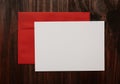 Blank white card template with red envelope on wooden background. Royalty Free Stock Photo