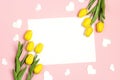 Blank white card with tulips flowers and hearts on pink pastel background. Flat lay, top view, copy space Royalty Free Stock Photo