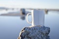 Blank white coffee mug on a salty post