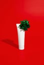 Blank white cosmetic plastic tube on red background with bow. Christmas Valentines day sale concept Royalty Free Stock Photo