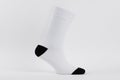 Blank white cotton long sock with black heel on invisible foot on white background as mock up for advertising, branding, design.