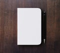 Blank white diary cover and pen on brown wooden table Royalty Free Stock Photo