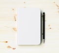 Blank white diary cover with pen on wooden table Royalty Free Stock Photo