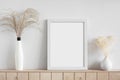 Blank white empty picture frame mockup on white wall. Home staging and minimalism concept.