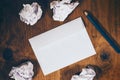 Blank white envelope, pencil and crumpled paper on wooden desk Royalty Free Stock Photo