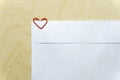 Blank white envelope on wooden desk with heart shaped paper clip Royalty Free Stock Photo