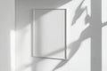 Blank white frame on modern wall reflecting daylight in minimalistic interior design Royalty Free Stock Photo