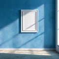 Blank White Frame on Textured Blue Wall with Sunlight and Shadows Royalty Free Stock Photo