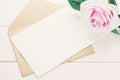 Blank white greeting card with brown envelope and purple rose Royalty Free Stock Photo