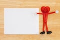 Blank white greeting card on a desk with a happy smiling heart